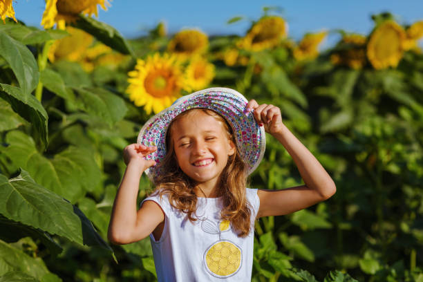 istock Beautiful smiling girl with straw hat in sunflower fields 1024575650