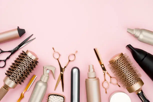 Photo of Various hair dresser tools on pink background with copy space