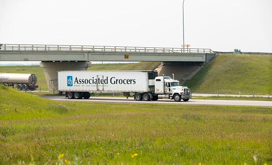 An Associated Grocers truck carrying cargo down a highway. Taken near Red Deer, Alberta. August 7, 2018
