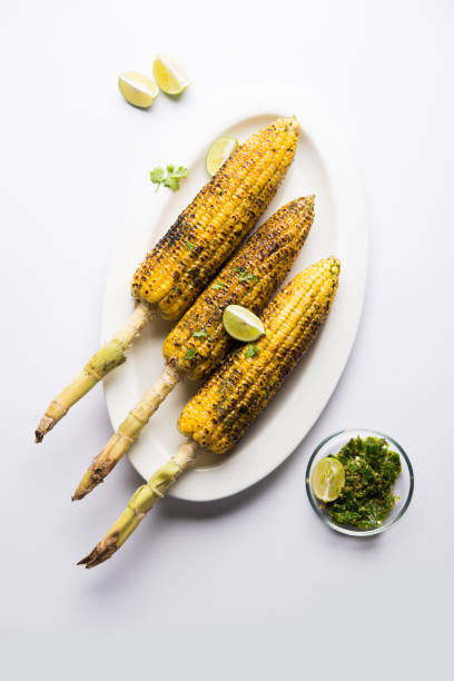 espiga de milho deliciosa rua índio também chamada bhutta, aromatizada com pimenta picante, manteiga etc. foco seletivo - corn corn on the cob grilled roasted - fotografias e filmes do acervo