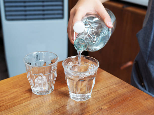 istock Pouring drinking water from glass bottle to glass shot. 1024598002