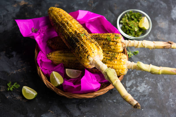 espiga de milho deliciosa rua índio também chamada bhutta, aromatizada com pimenta picante, manteiga etc. foco seletivo - corn corn on the cob grilled roasted - fotografias e filmes do acervo