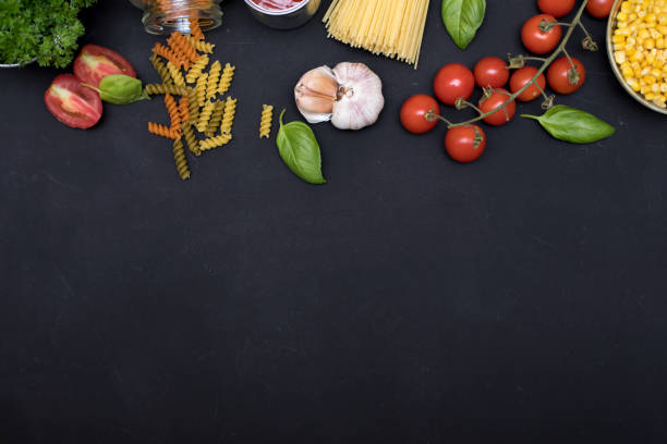 istock Food frame. Pasta ingredients. Cherry-tomatoes, spaghetti pasta, garlic, basil , cheese and spices on dark grunge backdrop, copy space, top view 1024607974
