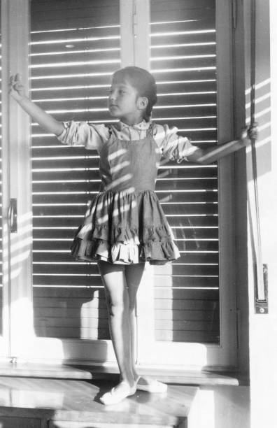 1955 fremale child dancing in front the window