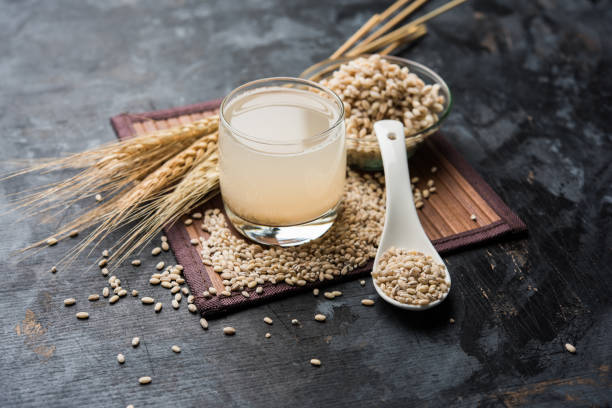 Barley water in glass with raw and cooked pearl barley wheat/seeds. selective focus stock photo