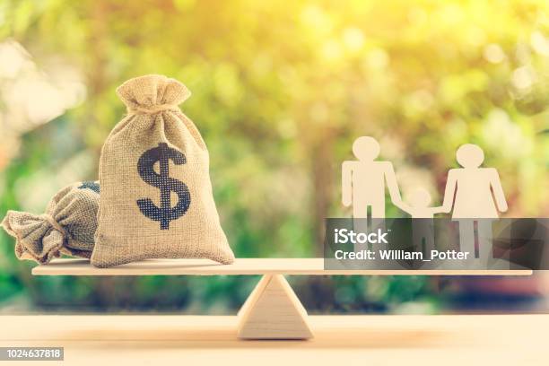 Money Saving For Kids Family Financial Wealth Management Concept Dollar Or Cash In Hemp Bags Or Burlap Sacks And A White Paper Cut On Wood Balance Scale Green Nature Background Stock Photo - Download Image Now