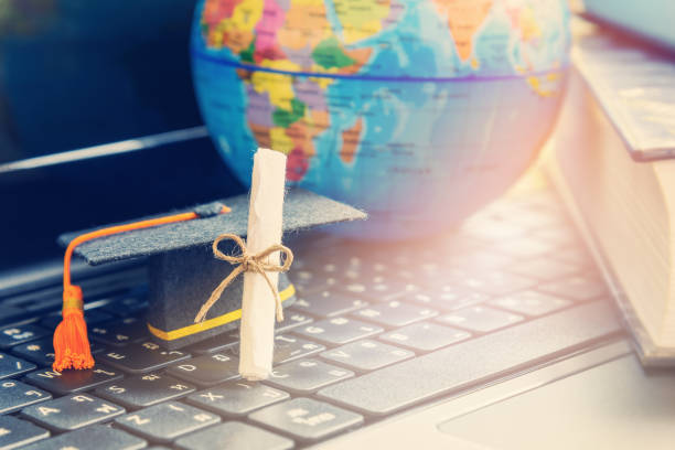 Graduate study abroad program concept : Diploma, graduation cap, a globe map and books, depicts knowledge can be learned online anywhere and everywhere, even in universities or campus around the world