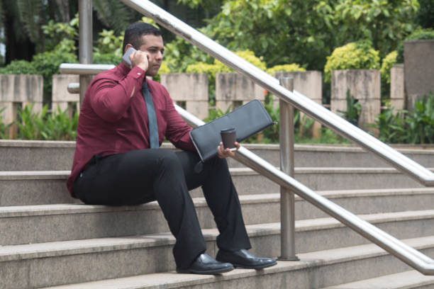 istock Businessman talking on mobile phone outdoors on stairs 1024640918