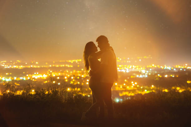 Photo of The couple hugs on the background of city lights. evening night time