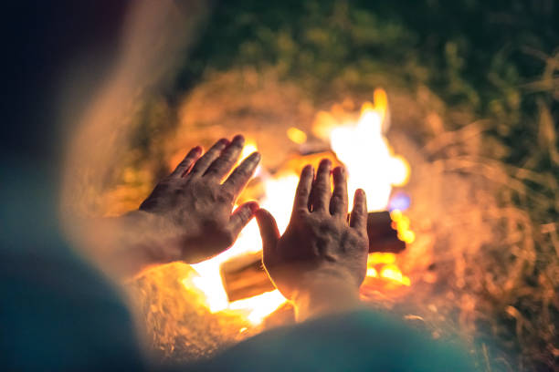 The man warming hands near the bonfire. night time