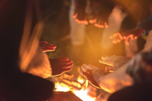 The people warming hands near a bonfire. evening night time
