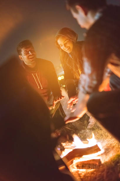 istock The happy friends warming hands near a bonfire. evening night time 1024669894