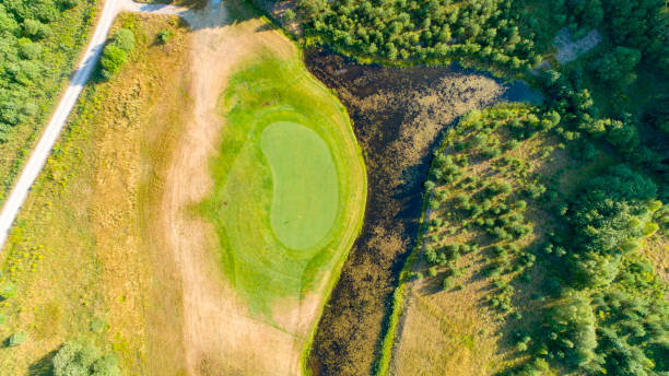 istock Golf green surrounded by water traps and forest 1024673846