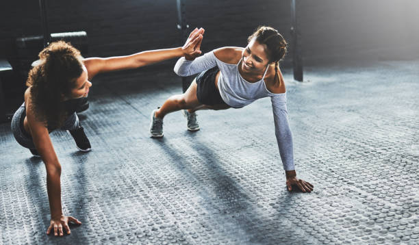 il lavoro di squadra fa funzionare l'allenamento - friendship women exercising gym foto e immagini stock