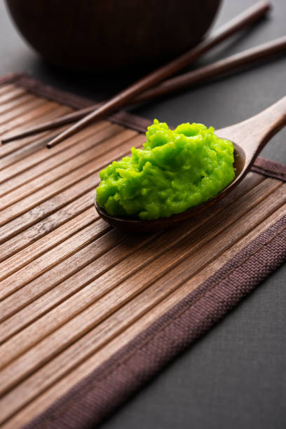 istock Green wasabi sauce or paste in bowl, with chopsticks or spoon over plain colourful background. selective focus 1024683942