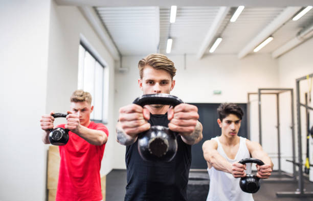istock Three young men in gym doing kettlebell swings. 1024684106