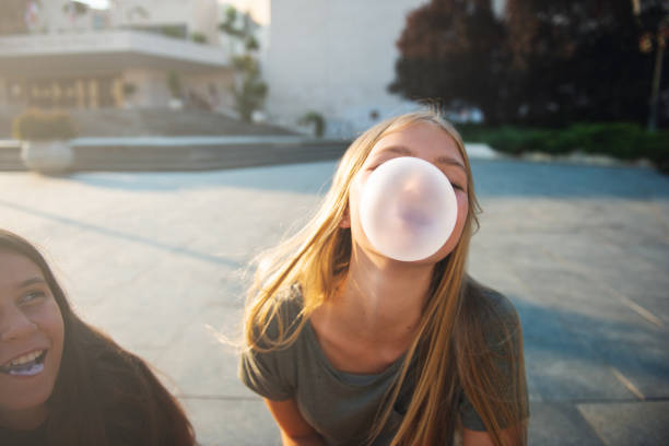 Teenage friends Two teenage girls having fun in the urban part of the city. They are making bubbles with bubble gum. bubble gum photos stock pictures, royalty-free photos & images