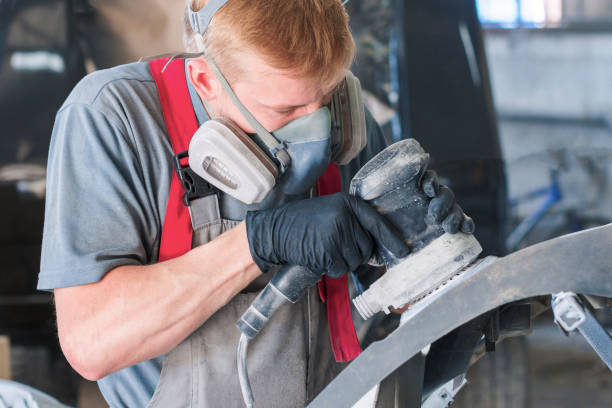 istock Auto mechanic grinds car part for painting 1024696464