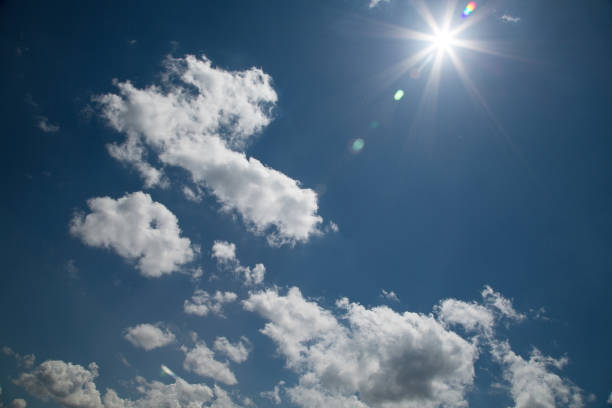 istock Real lents flare on blue sky with clouds and sun background with copy space 1024716946