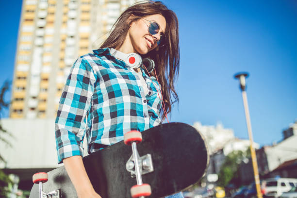 istock Girl in checkered shirt with skateboard 1024730134
