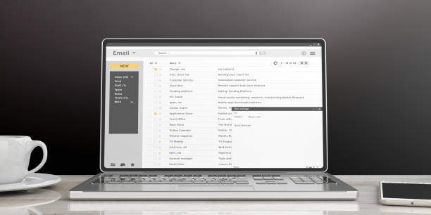 e-mails em uma tela de laptop isolado em uma mesa de escritório, fundo de parede preta. ilustração 3d - caixa de entrada de correio eletrónico - fotografias e filmes do acervo