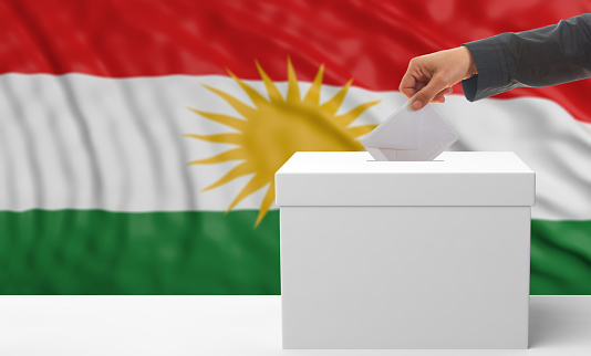 Elections in Kurdistan. Woman's hand puts an envelope in a white election ballot box on a waving Kurdistan flag background. 3d illustration