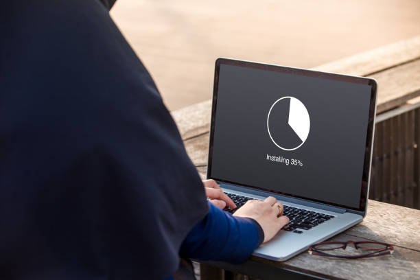 istock Hijab woman is working using laptop doing installing update with circle load percentage waiting indicator concept at outdoor 1024735202