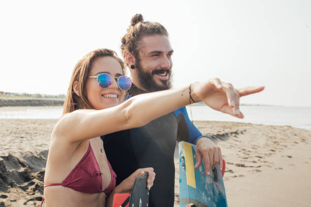 istock Happy surfing couple at the sunny beach 1024774850