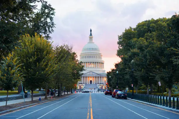 Photo shows the Capitol building in Washing D.C. in the evening golden hour, where the sky is in orange and pink color.
