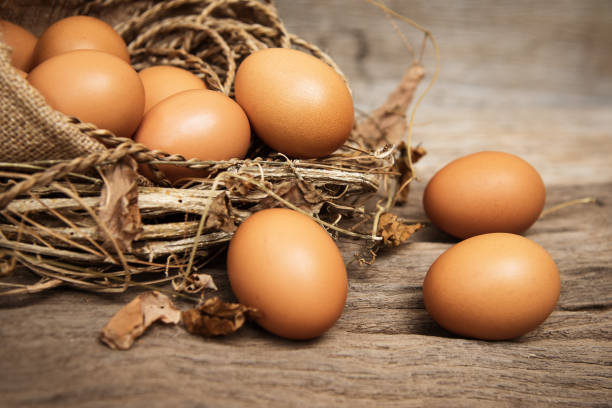 zbliżenie grupy surowego jaja umieścić na drewnianej desce z drewna, vintage i dźwięk sztuki, rozmazane światło wokół. - animal egg eggs basket yellow zdjęcia i obrazy z banku zdjęć