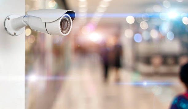istock CCTV camera on a wall white. security with supermarket blurred background 1024794306
