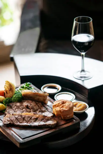 Photo of gourmet sunday roast beef traditional british meal set on old wooden pub table