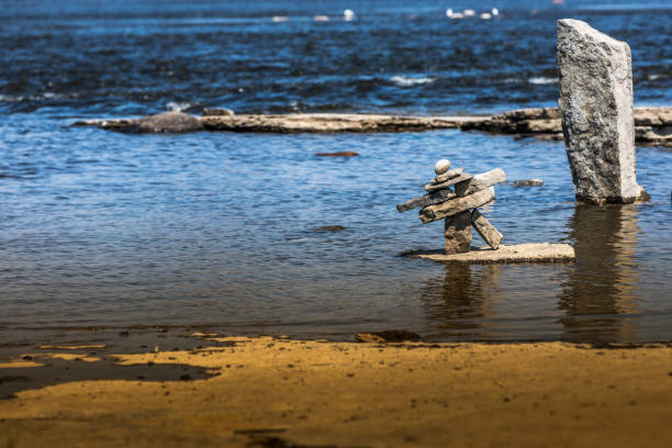 inukshuk nad brzegiem rzeki. - inunnguaq zdjęcia i obrazy z banku zdjęć