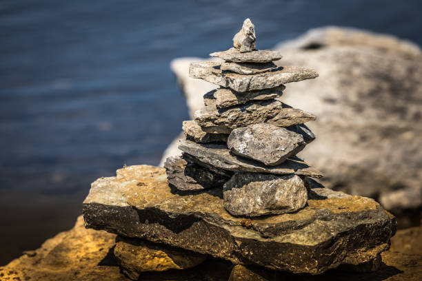 inukshuk nad brzegiem rzeki. - inunnguaq zdjęcia i obrazy z banku zdjęć