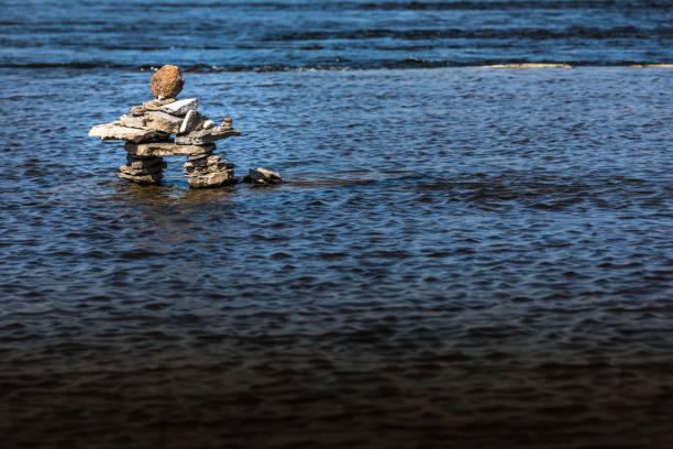 inukshuk nad brzegiem rzeki. - inunnguaq zdjęcia i obrazy z banku zdjęć