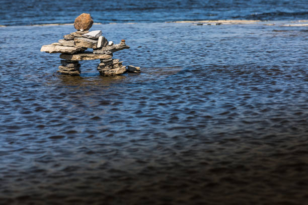 inukshuk nad brzegiem rzeki. - inunnguaq zdjęcia i obrazy z banku zdjęć