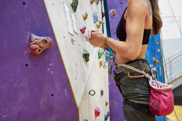 mulher com formação de corpo perfeito ajuste em uma parede de escalada no salão de esporte, pronto para o treino - people recreational pursuit exercising physical activity - fotografias e filmes do acervo