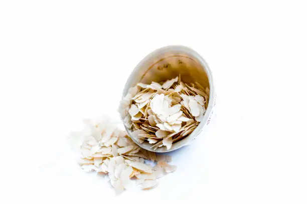 Photo of Close up of Flattened rice or beaten rice or Phoa or pava in a bowl isolated on white.