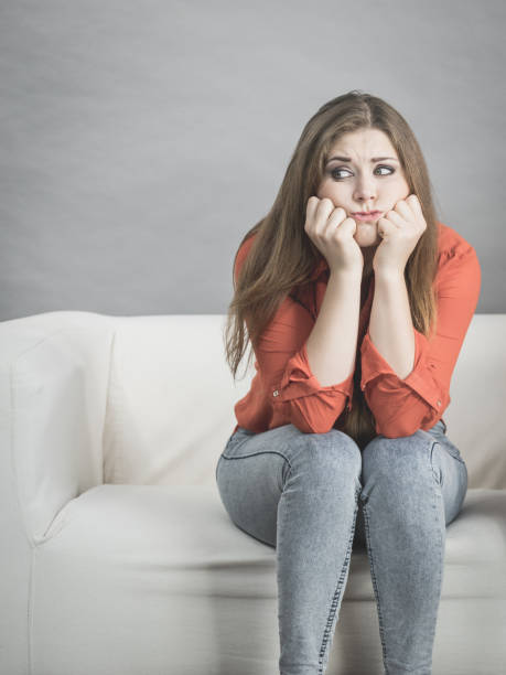 istock Worried woman sitting on sofa 1024817096