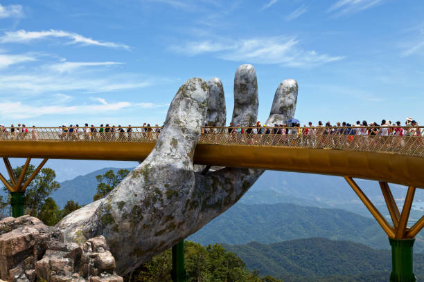 Golden Bridge in Ba Na Hills Bà Nà Hills, Vietnam - August 22 2018: The Golden Bridge is a 150 m long pedestrian bridge in the Bà Nà Hills, near Da Nang, Vietnam. The Bà Nà Hills are located in the Truong Son Mountains, which are part of the Annamite Range. bridge hand stock pictures, royalty-free photos & images