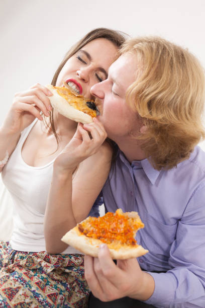 istock Couple eating pizza, having fun together. 1024828462