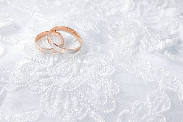 istock Wedding rings on wedding card, on a white wedding dress 1024832234