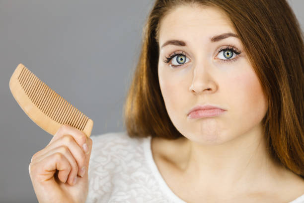 istock Attractive young woman being confused holding comb 1024834852