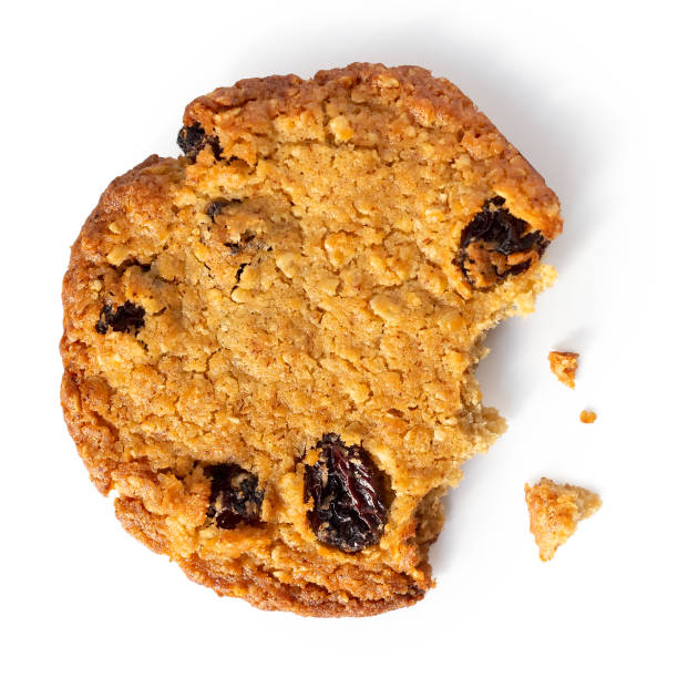 istock Partially eaten oat and raisin round biscuit isolated on white from above. 1024838154