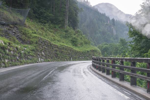 istock Rainy road surface and raindrops on a car windshield 1024875858