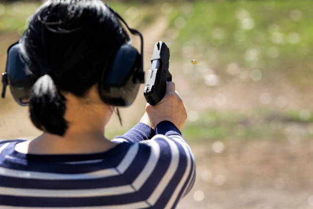 istock Woman shoots pistol at range. 1024898010