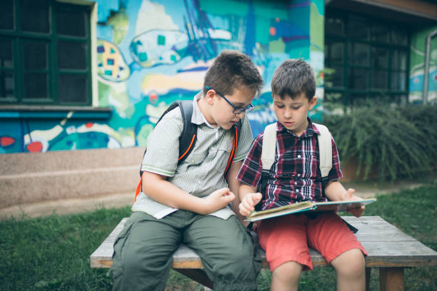 istock Boys read a book in a school yard 1024925132
