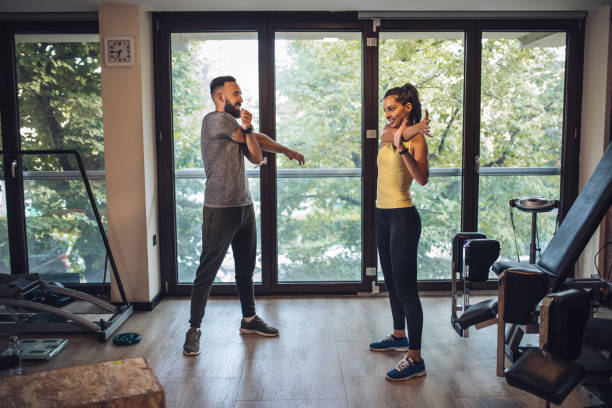 istock Handsome couple at gym stretching arms together 1024930546