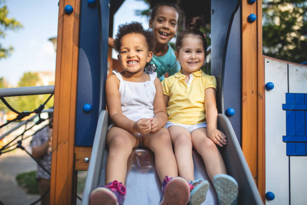 istock Gorgeous mixed race siblings sitting on a slide and smiling 1024940470