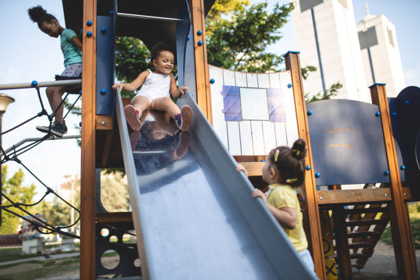 istock Lovely children playing on a playground slide 1024941108